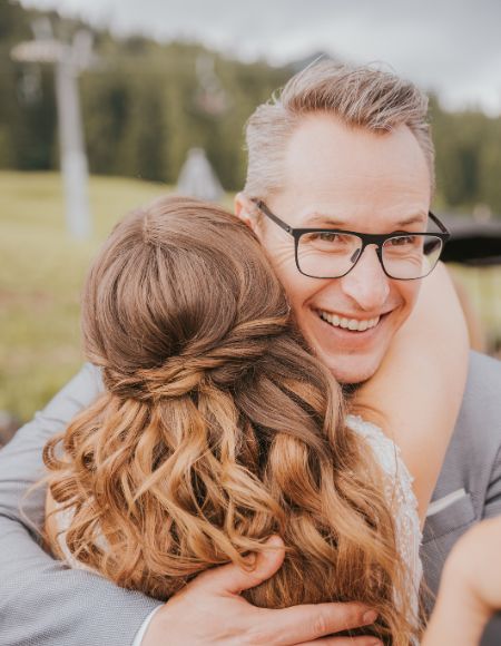 Traudredner Mike Metelko umarmt eine frisch getraute Braut.