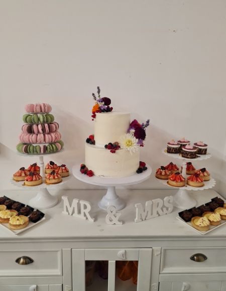 Auswahl an Macarons, diverse Törtchen, Muffins und Hochzeitstorte.