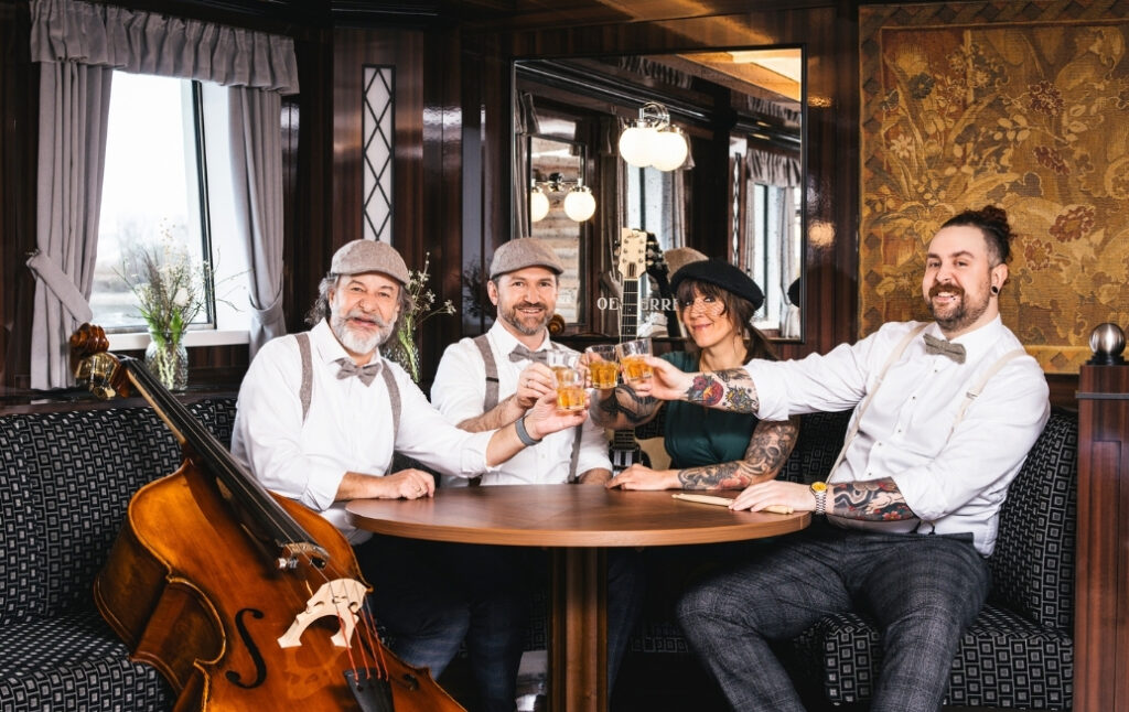 Bebe Jukes sitzen gemeinsam am Tisch in nostalgischer Atmosphäre